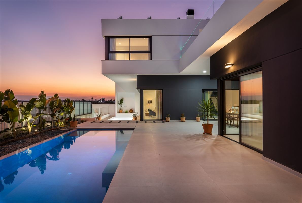 Modern villa terrace and swimming pool at sunset